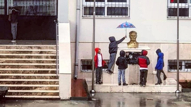 Atatürk büstünü saatlerce yağmurdan korudular