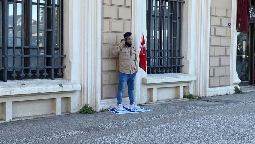İzmir'in Konak ilçesinde elinde Türk bayrağı, ayağının altında ise İsrail bayrağı olan bir şahıs başına silah dayadı.