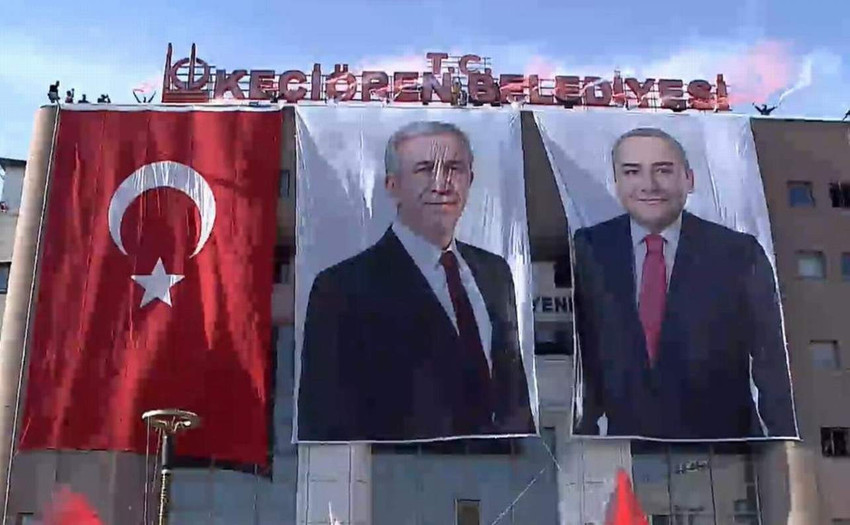 Keçiören Belediyesi devir teslim töreninde Ankara Büyükşehir Belediye başkanı Mansur Yavaş’ın kürsüye çıktığı anda, eski dönemde sökülen T.C. tabelası belediye binasına yeniden takıldı.