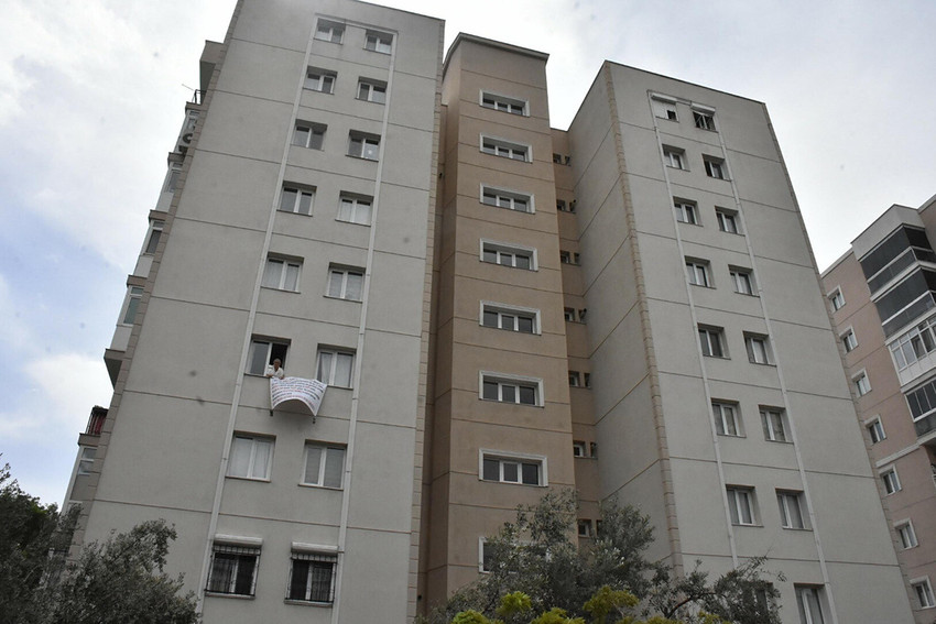 İzmir'de apartman görevlisinin saldırısına uğradığını iddia eden bir kadın sesini duyurmak için evinin camına pankart asıp başına gelenleri anlattı.