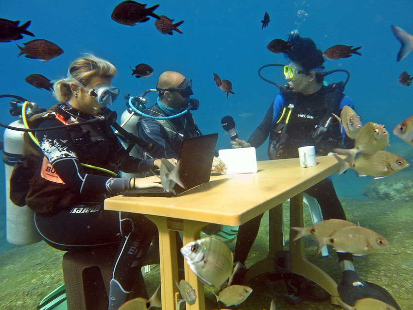 Fethiye'de Turizm Haftası kapsamında bir grup dalgıç su altında temsili olarak turizm sezonunu değerlendirdi. Dalgıçların su altına masada oturup, bilgisayar ve mikrofon kullandıkları o anlar su altı kamerasıyla görüntülendi.