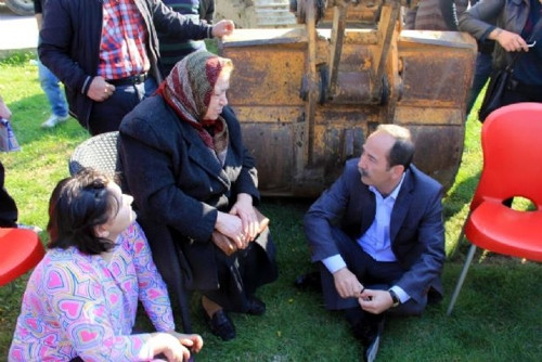 Kepçenin önünde oturdu