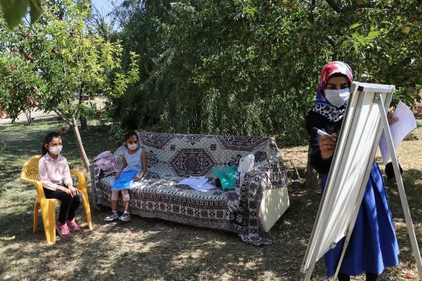 Gamze öğretmen, elinde tahtasıyla kapı kapı dolaşıp ders anlatıyor