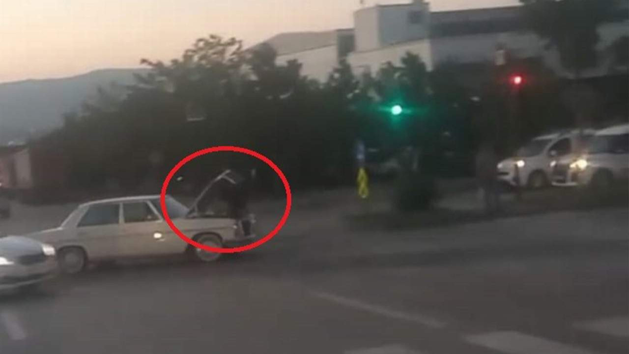 Giden otomobilin üzerinde araç tamiri kamerada